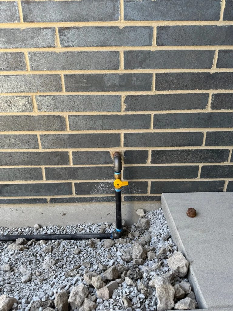 Exterior gas line and shutoff valve at a brick building